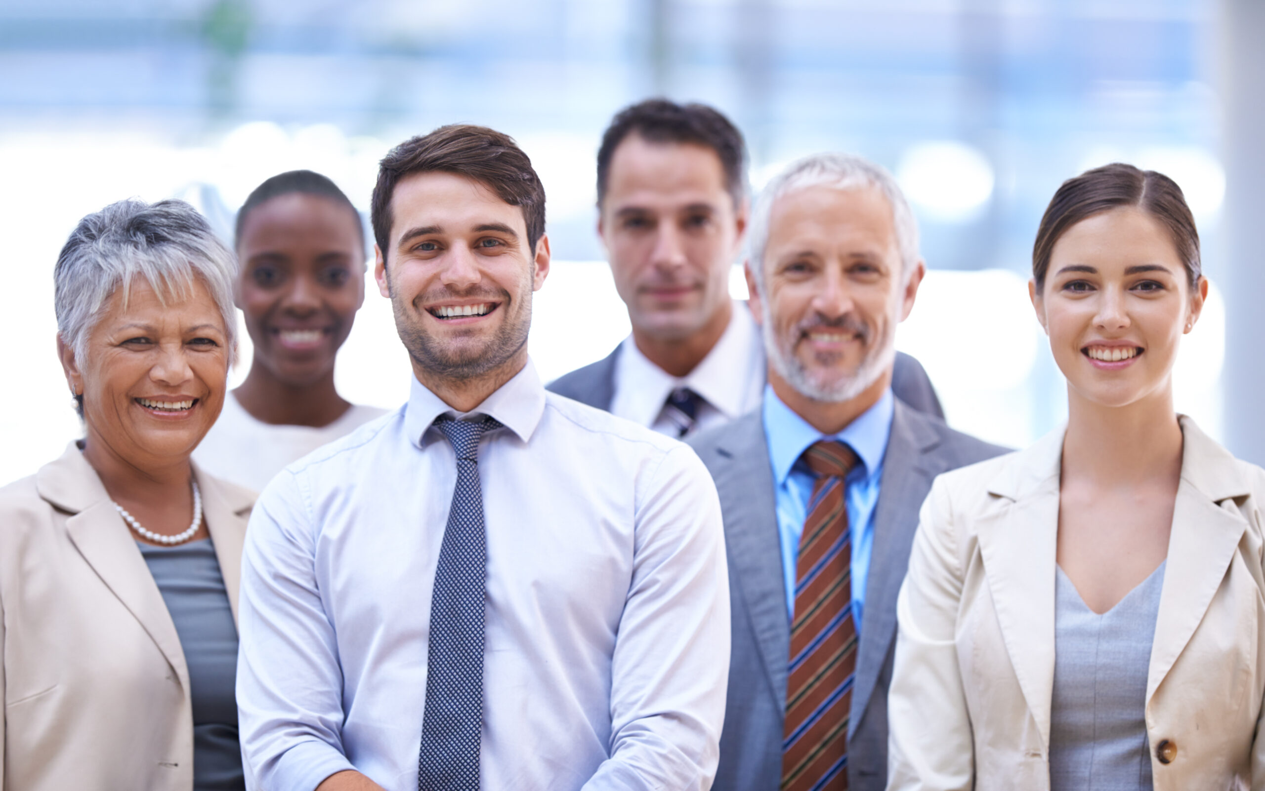 A group of smiling professionals together in an office